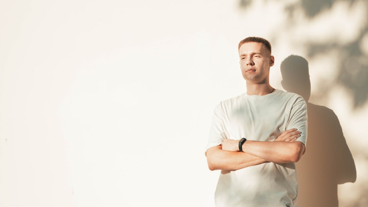 portrait of a young boy with his arms crossed on his chest in the soft shadows of the setting sun